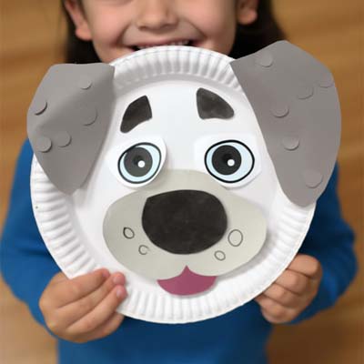 dog with big eyebrows paper plate craft held by a child