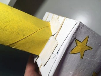 Cut and glue the paper towel roll to the carboard box.