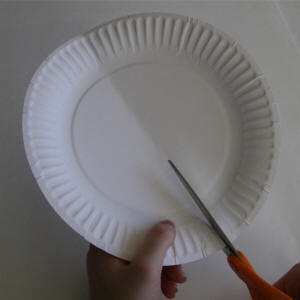 Fold and cut the paper plate in half.