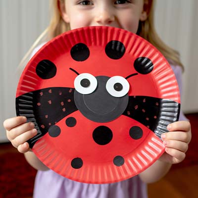 Paper Plate Ladybug Craft held by a child