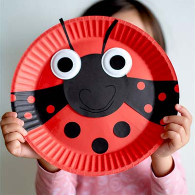 Paper Plate Ladybug Craft held by a child