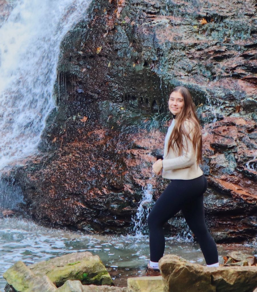 Walking in front of waterfall.