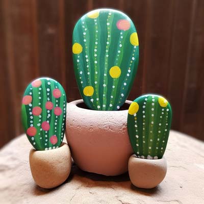 cacti painted on a rocks and displayed in terra cotta pinch pots